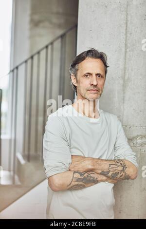 Porträt eines tätowierten älteren Mannes in einer Loft-Wohnung Stockfoto