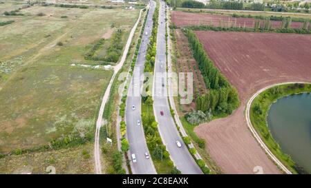 Luftaufnahme der zweispurigen Straße in der Nähe der landwirtschaftlichen Felder. Stockfoto