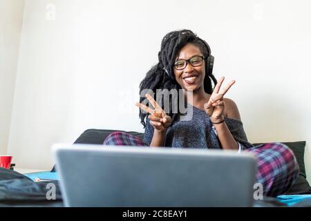 Junge Frau mit Laptop am Bett zu Hause Stockfoto