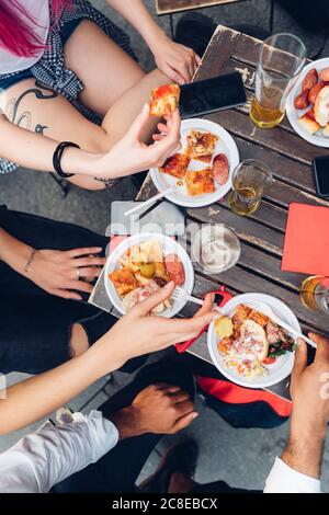 Freunde sitzen am Tisch im Freien essen Snacks Stockfoto