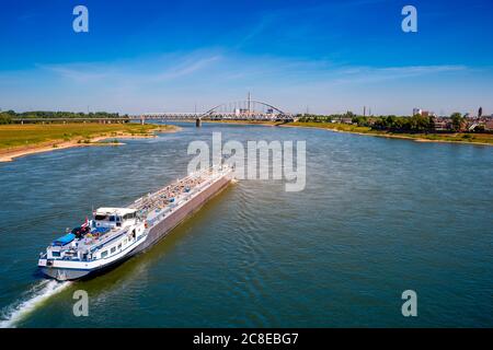 Deutschland, Nordrhein-Westfalen, Düsseldorf, Tanker über Rhein mit Brücke im Hintergrund Stockfoto