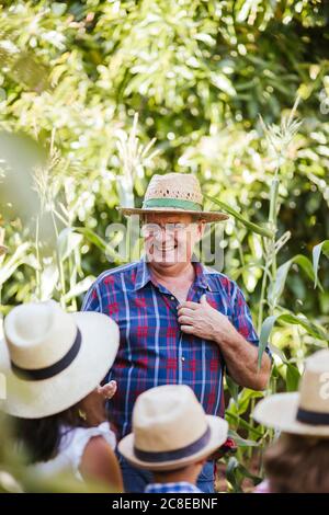 Grandfahter mit Gruppe von Kindern im Garten Stockfoto