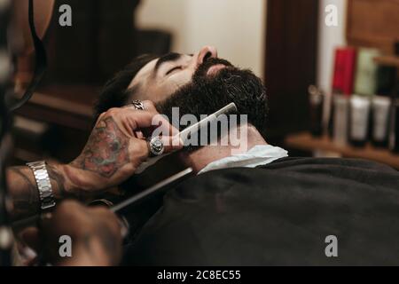 Friseur kämmt den Bart des Kunden im Salon Stockfoto