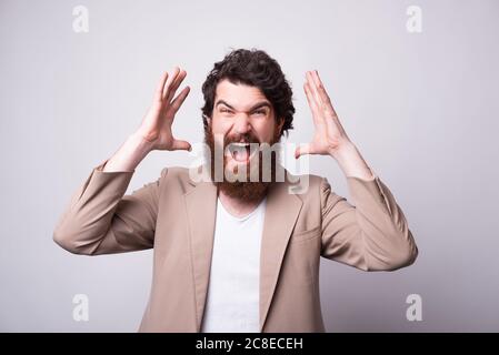 Wütend oder aufgeregt bärtigen Mann macht min Schlag Geste über weißen Hintergrund. Stockfoto