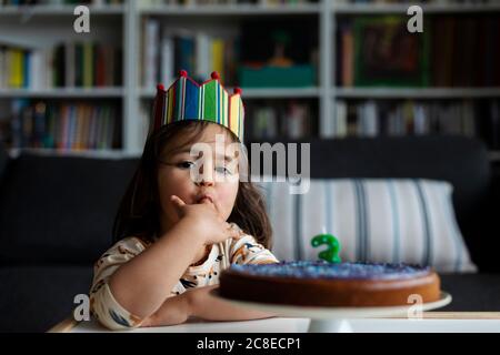 Portrait von kleinen Mädchen Verkostung Geburtstagskuchen Stockfoto