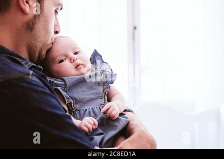 Nettes Baby Mädchen wird von Vater zu Hause getragen Stockfoto