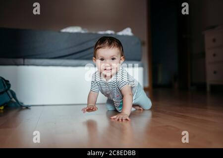 Portrait von lächelnd Baby Mädchen kriechen auf dem Boden des Schlafzimmers Stockfoto