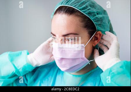 Nahaufnahme einer Krankenschwester, die eine OP-Maske trägt und in die sie wegschaut Klinik Stockfoto