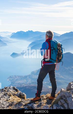 Wanderer, der auf dem Berg steht und auf den Comer See blickt, Italien Stockfoto