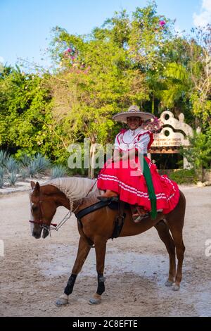 Der junge amazonas reitet ein reinrassiger Pferd für eine Reitausstellung im Xcaret Park an der Maya Riviera in Mexiko Stockfoto