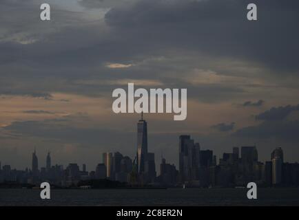 Bayonne, Usa. Juli 2020. Am Donnerstag, den 23. Juli 2020, ziehen Gewitterwolken über die Freiheitsstatue, das One World Trade Center und die Skyline von Manhattan, bevor es in Bayonne, New Jersey, untergeht. Foto von John Angelillo/UPI Kredit: UPI/Alamy Live Nachrichten Stockfoto