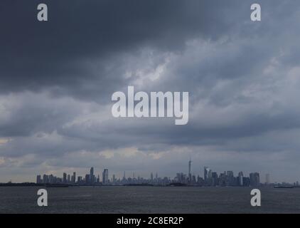 Bayonne, Usa. Juli 2020. Am Donnerstag, den 23. Juli 2020, ziehen Gewitterwolken über die Freiheitsstatue, das One World Trade Center und die Skyline von Manhattan, bevor es in Bayonne, New Jersey, untergeht. Foto von John Angelillo/UPI Kredit: UPI/Alamy Live Nachrichten Stockfoto