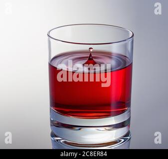 Tropfen Rotwein in Glas aus nächster Nähe. High-Speed-Aufnahme. Wellen im Glas Stockfoto