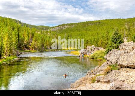 Wyoming, USA - 24. August 2019: Besucher schwimmen und abkühlen sich am Firehole River im Yellowstone National Park, Wyoming, USA. Der Fluss fließt durch Stockfoto