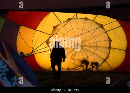 Silhouette eines Piloten und Crews, die sich im Ballon vor dem Start im Singha Park in Chiang Rai, Thailand, aufhalten. Stockfoto