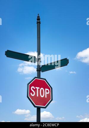 Ein Stoppschild und leere Straßenschilder gegen blauen Himmel und weiße Wolken. Platz für Ihren benutzerdefinierten Text. Konzept für die Entscheidungsfindung, zwei Alternativen. Stockfoto