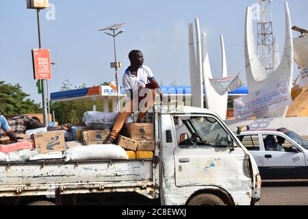 Ein Arbeiter, der auf der Last eines Lieferwagens in Niamey, Niger, sitzt. Stockfoto