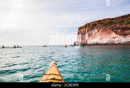 Eine geführte Kajakfahrt auf der Isla Espirito Santo, Golf von Kalifornien, BCS, Mexiko, vor der Küste unter den hohen Sandsteinklippen. Stockfoto