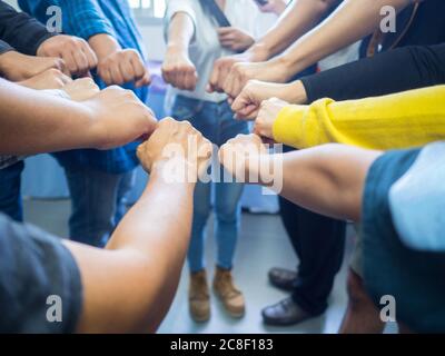 Nahaufnahme vieler Menschen zeigen Hände, wie sie ihre Fäuste als Symbol der Einheit zusammenfügen. Konzept der Teamarbeit Stockfoto