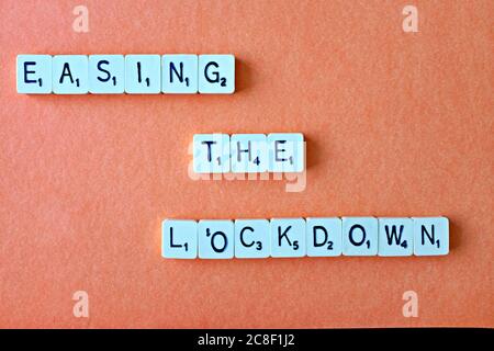 Die Wörter - Lockdown - buchstabiert heraus in quadratischen Buchstaben auf einem bernsteinfarbenen Hintergrund, mit reichlich redaktionellen/copy Raum Stockfoto