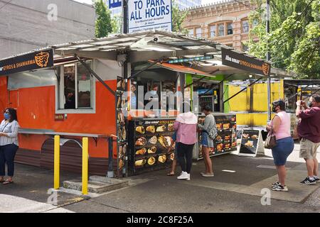 Kunden stehen bei Abu Omar Gyros & Shawarma in der 3rd Ave Food Cart Pod in der Innenstadt von Portland an. Die schlichte, nur Karren-Pod wird Gyro District genannt. Stockfoto