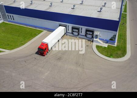 Luftaufnahme von Lkw entladen in logostics Center Stockfoto