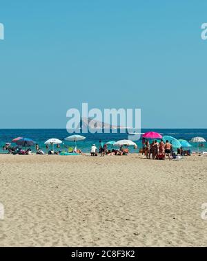 Benidorm, Alicante, Spanien, Juli 20,2019.viele Touristen am westlichen Strand der Stadt.Bunte Sonnenschirme und weißer Sand im Hintergrund die berühmte Insel Stockfoto