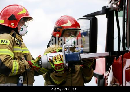 Feuerwehrmann bremst während des Übungsvorgangs eine Tür einer LKW-Kabine mit der schweren Ausrüstung. Die Freiwillige Feuerwehr auf dem Gelände der man Trucks fa Stockfoto