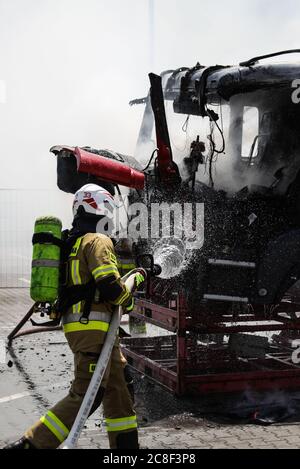 Ein Feuerwehrmann in schwerer Ausrüstung gesehen, während das Feuer löschen. Die Freiwillige Feuerwehr auf dem Gelände der man Trucks Fabrik führt die Unverwahrend Stockfoto