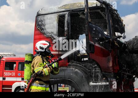 Ein Feuerwehrmann in schwerer Ausrüstung gesehen, während das Feuer in einer Kabine eines LKW. Die Freiwillige Feuerwehr auf dem Gelände der man Trucks Stockfoto