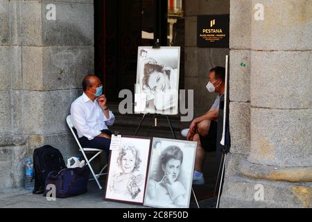 23. Juli 2020, Plaza Mayor, Madrid, Spanien: Ein Straßenkünstler trägt eine Gesichtsmaske, während er sich mit einem Freund auf der zentralen Plaza Mayor / Great Square unterhält. Viele europäische Länder kehren nach der Aussperrung langsam zum normalen Leben zurück, um die Ausbreitung des Covid-19-Coronavirus zu verhindern, mit sozialer Distanzierung, Maskenverschleißungen und anderen Einschränkungen. In Spanien ist das Tragen von Masken im öffentlichen Verkehr, in Geschäften und geschlossenen öffentlichen Räumen obligatorisch. Trotz dieser Kontrollen wurden in einigen Teilen Spaniens lokale Sperren verhängt, um neue Ausbrüche des Virus zu kontrollieren. Stockfoto