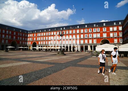 23. Juli 2020, Plaza Mayor, Madrid, Spanien: 2 Touristen mit Gesichtsmasken gehen über einen nahe leeren Plaza Mayor / Großen Platz. Seit dem 21. Juni hat Spanien die Reisebeschränkungen nach einer strengen Sperre zur Kontrolle des Covid 19-Coronavirus gelockert, und die europäischen Länder haben Grenzen geöffnet und Flugbrücken koordiniert, um Reisen und Tourismus zu ermöglichen, die wirtschaftlichen Auswirkungen des Virus zu reduzieren. Spanien ist eines der meistbesuchten Länder der Welt und der Tourismus ist ein wichtiger Beitrag zur spanischen Wirtschaft. Die Plaza Mayor ist eine der Hauptattraktionen Madrids und ist normalerweise voller Menschen und Touristen Stockfoto