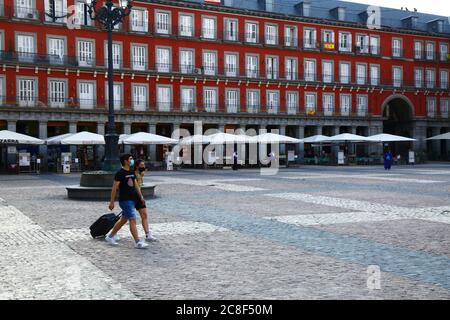 23. Juli 2020, Plaza Mayor, Madrid, Spanien: Touristen mit Gesichtsmasken gehen über einen nahe leeren Plaza Mayor / Großen Platz. Seit dem 21. Juni hat Spanien die Reisebeschränkungen nach einer strengen Sperre zur Kontrolle des Covid 19-Coronavirus gelockert, und die europäischen Länder haben Grenzen geöffnet und Flugbrücken koordiniert, um Reisen und Tourismus zu ermöglichen, die wirtschaftlichen Auswirkungen des Virus zu reduzieren. Spanien ist eines der meistbesuchten Länder der Welt und der Tourismus ist ein wichtiger Beitrag zur spanischen Wirtschaft. Die Plaza Mayor ist eine der Hauptattraktionen Madrids und ist normalerweise voller Menschen und Touristen Stockfoto