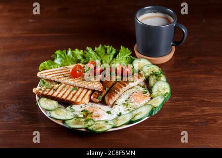 Sandwiches mit Würstchen, Dill und einem Zweig Basilikum auf einem weißen Teller auf einem Holztisch erröten. Die Idee des schnellen Kochens. Nahaufnahme. Stockfoto