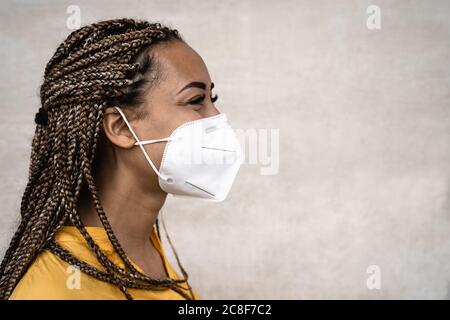 Afrikanische Frau mit Zöpfen tragen Gesicht medizinische Maske - Junges Mädchen mit Gesichtsmaske zur Verhinderung und stoppen Corona Virus Ausbreitung Stockfoto