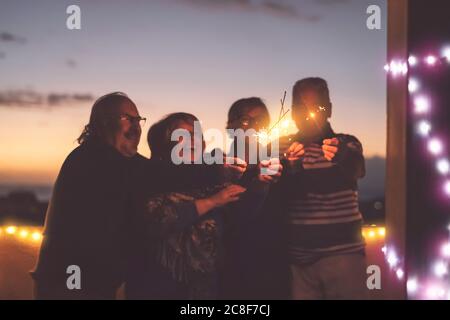 Senioren Freunde Spaß haben gemeinsam Urlaub feiern im Freien - glücklich ältere Menschen genießen Party lachen auf der Terrasse bei Sonnenuntergang Stockfoto