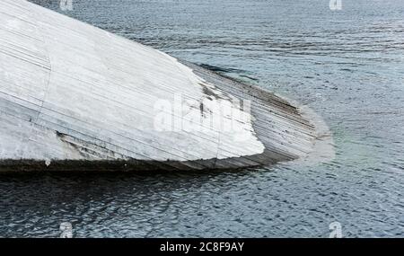 Betonkonstruktion, die in einem schrägen Winkel ins Wasser geht. Stockfoto
