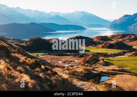 Berge spiegeln sich an der Oberfläche eines unglaublich ruhigen Lake Wanaka, an einem klaren, ruhigen Tag auf Neuseelands Südinsel Stockfoto