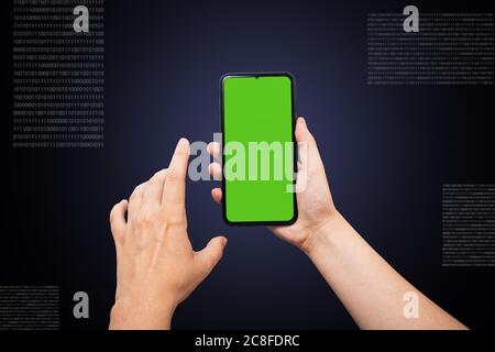 Hände halten das Telefon mit einer grünen Chromaque, die Rückseite schwarz blau Hintergrund mit Zahlen und Zahlencode. Technologie, Versorgungsunternehmen, Kommunikation. Stockfoto