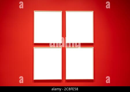 Vier weiße quadratische Mockup auf einer roten Wand. Stockfoto
