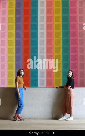 Mitarbeiter tragen kunstkunstkunstvolle Masken, während sie vor Jenny Holzers "inflammatory Essays" in der Tate Modern stehen, während sich die Galerie nach der Sperrung des Coronavirus am Montag, dem 27. Juli, für die Öffentlichkeit öffnet. Stockfoto