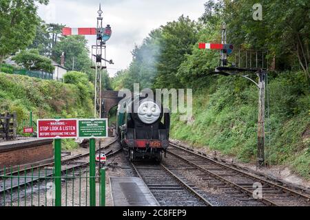 Ein Tag mit Thomas, dem Panzerlokomotive und Freunden: Dampflokomotive der Schulklasse mit Gesicht, nähert sich der Station Alresford auf der Watercress Line Stockfoto
