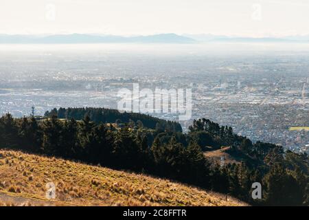 Eine dünne Dunstschicht über der Stadt Christchurch, Neuseeland, vom Sugarloaf Scenic Reserve aus gesehen Stockfoto