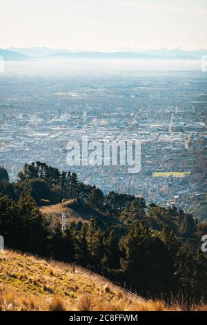 Eine dünne Dunstschicht über der Stadt Christchurch, Neuseeland, vom Sugarloaf Scenic Reserve aus gesehen Stockfoto