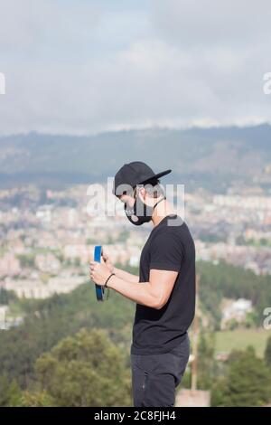 Vertikale Aufnahme eines jungen Mannes, der draußen im Freien arbeitet Eine Maske Stockfoto