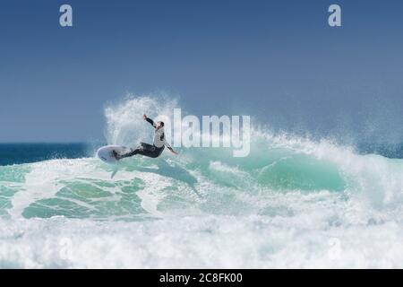 Spektakuläre Action, während ein Surfer eine Welle in Fistral in Newquay in Cornwall reitet. Stockfoto