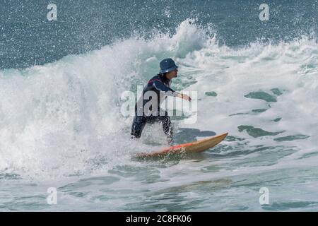 Spektakuläre Action, während ein Surfer eine Welle in Fistral in Newquay in Cornwall reitet. Stockfoto