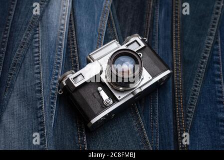 Alte Retro-Filmkamera auf Denim-Hintergrund. Blick von oben. Weichfokus Stockfoto