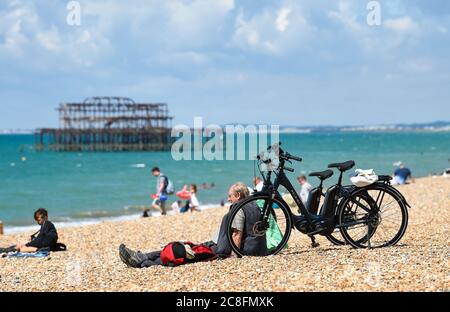 Brighton UK 24. Juli 2020 - Besucher genießen einen heißen sonnigen Tag am Brighton Strand mit Temperaturen prognostiziert, um 25 Grad in einigen Teilen des Südostens heute : Credit Simon Dack / Alamy Live News Stockfoto