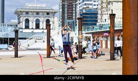 Brighton UK 24. Juli 2020 - dieser Kerl geht an einem heißen sonnigen Tag zwischen den Golden Spiral Säulen an der Küste von Brighton und die Temperaturen werden heute in einigen Teilen des Südostens auf 25 Grad Celsius steigen : Credit Simon Dack / Alamy Live News Stockfoto